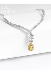 Macro shot of a teardrop-shaped yellow gemstone pendant with V-shaped diamond setting