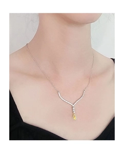 Detail view of pear-cut yellow diamond pendant with micro-pave halo on a silver chain
