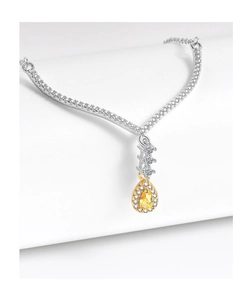 Macro shot of pear-shaped yellow zircon pendant on a sparkling diamond V-shaped necklace