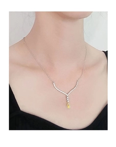 Close-up of a pear-shaped yellow diamond pendant with a V-shaped pavé diamond setting