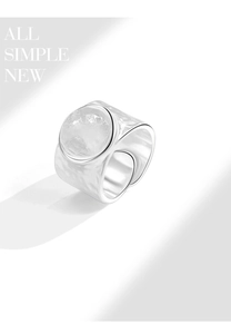 Detailed view of silver wide ring with hammered texture and translucent round gemstone