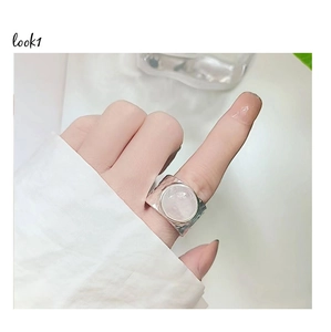 Detail of wide silver hammer-textured ring with a large round pink crystal inlay