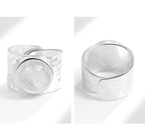 Detail view of silver irregular hammered texture ring with round metal inlay and split band