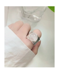 Detail of a wide silver moonstone ring with hammered texture on a hand model