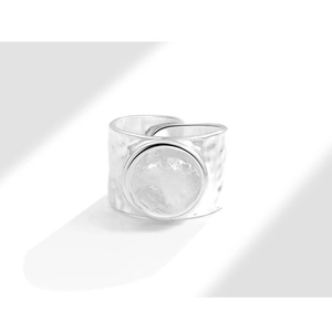 Detail of silver textured open ring featuring a hammered surface and central round disc