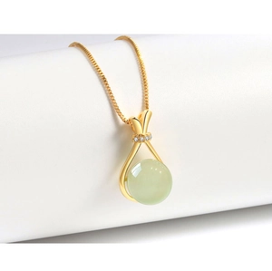 Detailed macro of S925 silver gold lucky bag necklace with green jade and box chain
