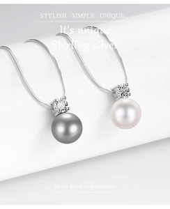 Detail van de S925 sterling zilveren parelketting met witte en donkergrijze hangers