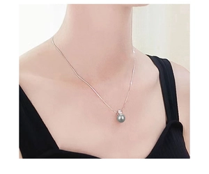 Detail van een S925 zilveren ketting met een ronde grijze parel en zirkoonaccenten