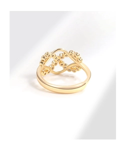 Macro de la bague en or montrant le tissage infini complexe et les diamants étincelants