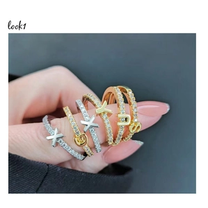 Detail of adjustable alphabet rings in gold and silver plating with zircon pavé setting