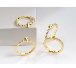 Detailed close-up of 18K gold plated adjustable rings with micro-pave cubic zirconia letters