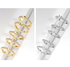 Detail of 18K gold and silver plated letter rings with shimmering micro-paved zircons