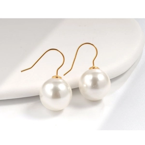 Dettaglio di orecchini di perle in argento s925 con ganci dorati su espositore bianco