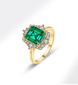 Detailed close-up of a luxury emerald cut green gemstone ring with pavé diamond halo