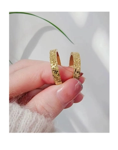 Close-up of golden hammered texture rings showing detailed metallic finish and craftsmanship