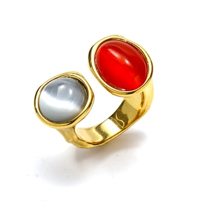 Detail eines verstellbaren Goldrings mit zwei großen roten und grauen Edelsteinen