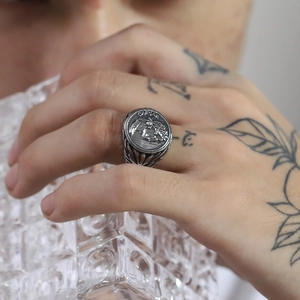 Detailed view of the embossed Julius Caesar portrait and engraved floral patterns on the ring