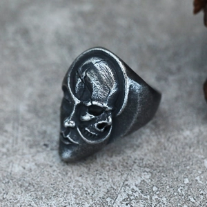 Macro shot of gothic split-face ring with skull and mask details in vintage steel