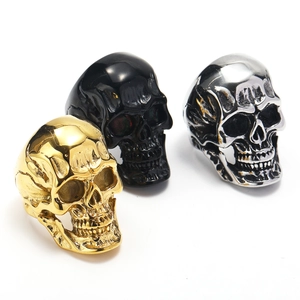 Detailed view of punk skull rings in gold, black, and silver finishes with metallic luster