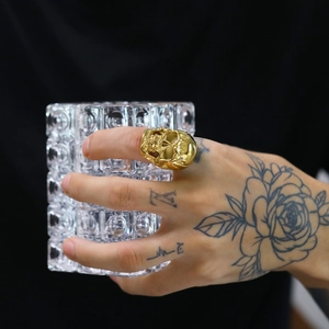 Detailed close-up of a gold punk skull ring featuring intricate 3D carving and polished finish