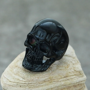 Detailed view of punk black skull ring on stone with high-quality stainless steel texture