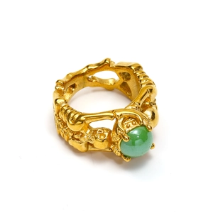 Detailed macro view of retro gold skull ring featuring a polished green ceramic stone inlay