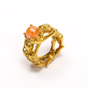 Gothic punk gold skull ring featuring a vibrant orange bead and intricate engravings