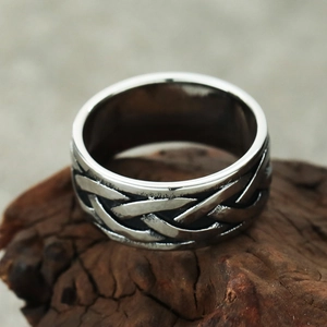 Bague Viking vintage en acier inoxydable avec nœud celtique sur un socle en bois