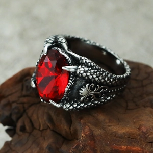 Detail of vintage dragon claw ring featuring a large oval red faceted gemstone setting