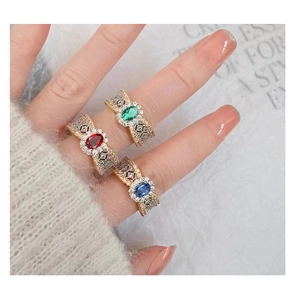 Detailed macro view of vintage emerald rings with intricate lace-pattern engraving