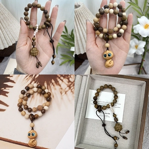 Handcrafted sandalwood bead bracelet with zodiac snake pendant and pinecone charm