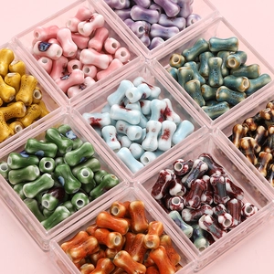 Colorful bone-shaped ceramic beads in various colors stored in a grid box for DIY crafts