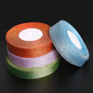 Close-up of glitter mesh ribbons in orange, purple, green, and blue for gift wrapping