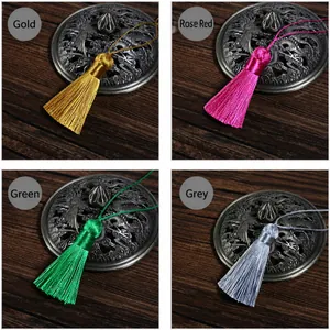 Macro detail of vintage silk tassels in yellow, rose, green, and grey on wood