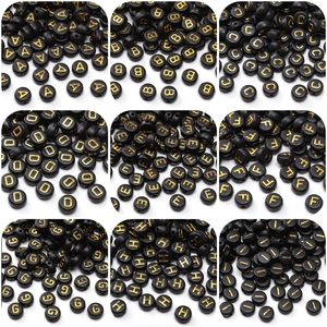 Macro view of 4x7mm black acrylic beads with gold letters for DIY jewelry making