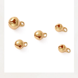 Gros plan de pendentifs cloches dorés 18K polis de différentes tailles avec boucles
