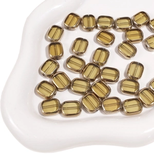 Macro shot of 10x12mm amber glass beads with gold trim edges for DIY jewelry making