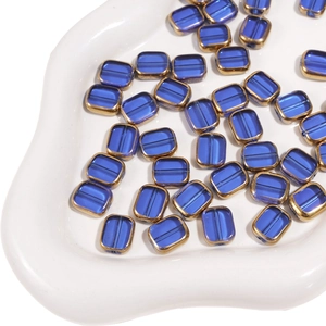 Macro shot of 10x12mm dark blue glass beads with gold trim for DIY jewelry making