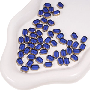 Macro detail of dark blue 6x9mm faceted glass beads with gold plated metal edges