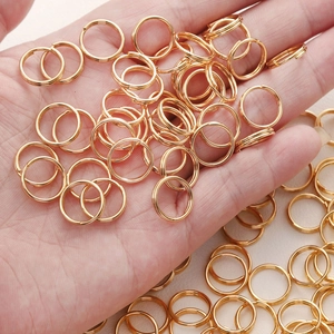 Gouden roestvrijstalen dubbele ringen voor DIY-sieraden, vastgehouden voor schaal