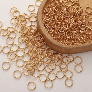 Nahaufnahme goldener Edelstahl-Spaltringe für Schmuck auf einem Holztablett