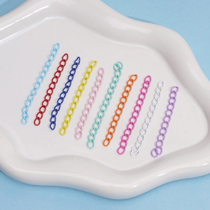 Set of ten colorful metal chains in assorted matte colors displayed on a ceramic tray