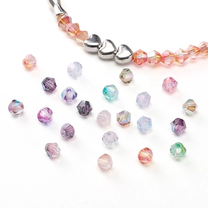 Détail de perles bicolores facettées en verre avec breloques cœur pour bijoux DIY
