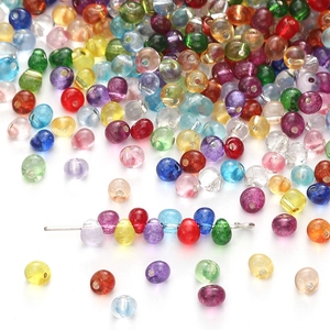 Macro shot of 4mm colorful transparent glass beads on a silver needle for DIY jewelry