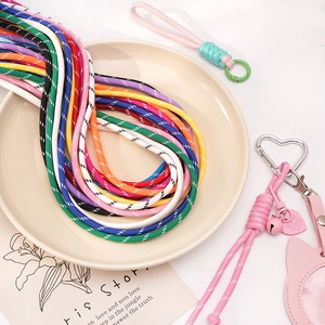 Detail of colorful braided cords with metal heart clasps and cat pendants for DIY crafts