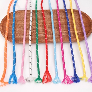 Macro shot of colorful 5mm braided polyester cords with white dots on a wooden tray