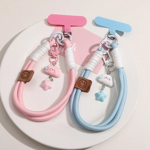 Macro shot of colorful braided phone lanyards with star and cloud charms on a white plate