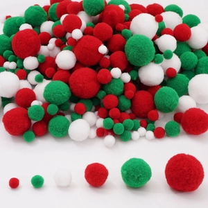 Macro detail of various sizes of red green and white Christmas pom poms on white background
