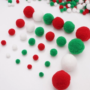 Close-up of red white and green festive pom-poms in various sizes for DIY crafts