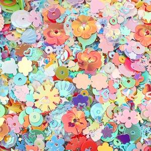 Macro view of macaron colored iridescent sequins in flower heart and star shapes